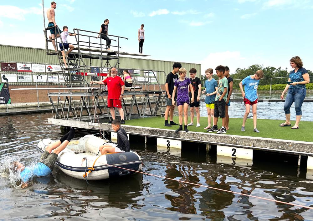 Kinderburgmeester kijkt hoe kind uit bootje valt.