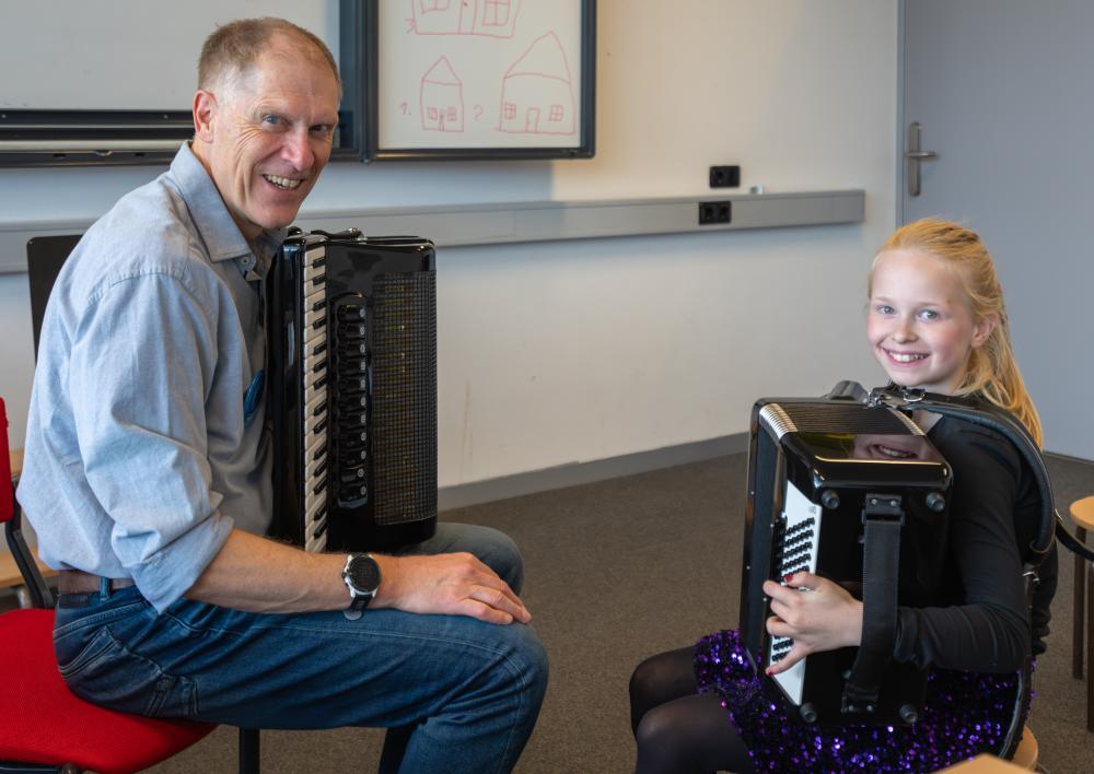 Een kind en een man met een accordeon