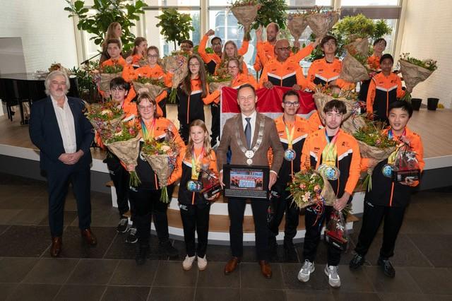 De wethouders met de sporters op het podium
