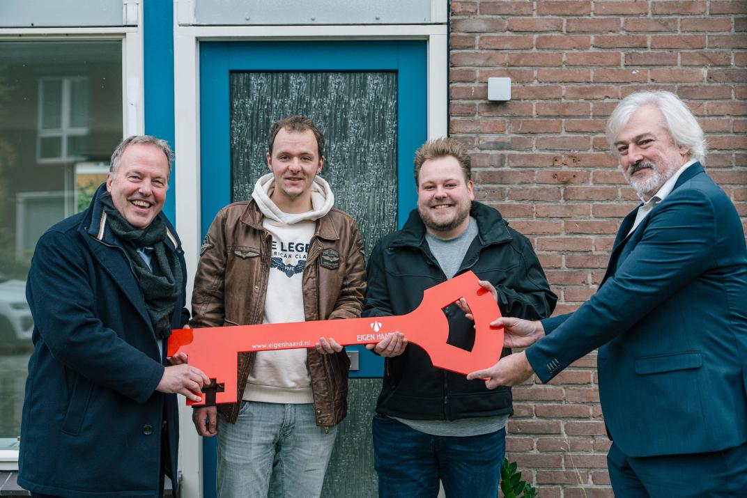 Overhandiging van een grote rode sleutel