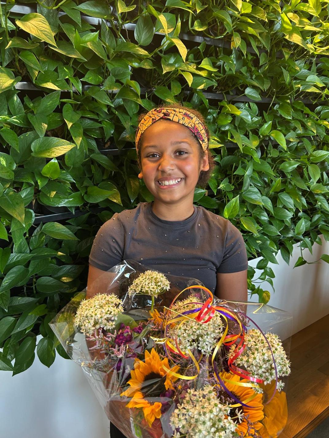 Kinderburgemeester Julyanah met een bos bloemen